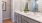 Large well lit bathroom with large mirror and tan cabinets 