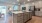 Spacious and well lit kitchen with wood floors and stainless steel appliances. 